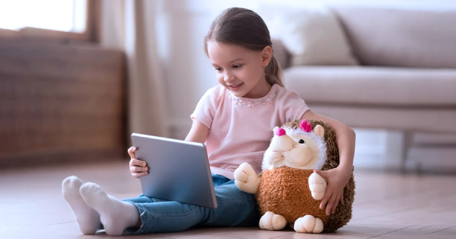An image of a small girl looking at her tablet.