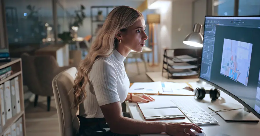 A female developer working with a desktop in her front. 