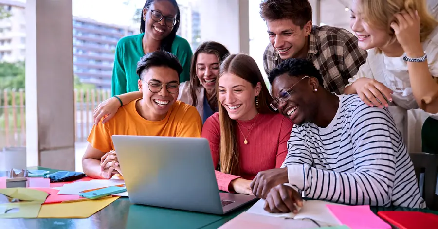 A multicultural group of college students looking at the laptop and learning about AI for career counseling 