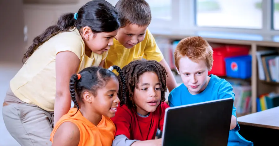  A multi-ethnic group of elementary school students learning about the best cloud migration tools for edtech.