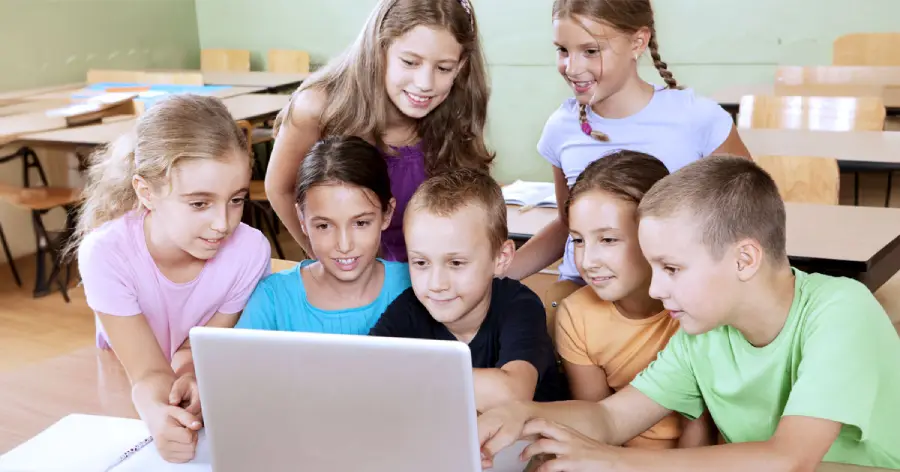 A multi-cultural group of students on a laptop learning about the tools for custom content development.