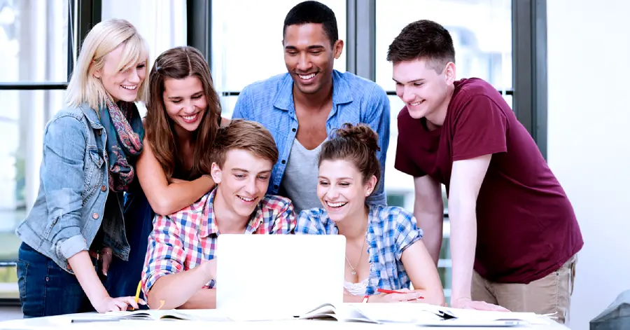 A multiracial group of college students learning about ethical AI in education on a laptop.