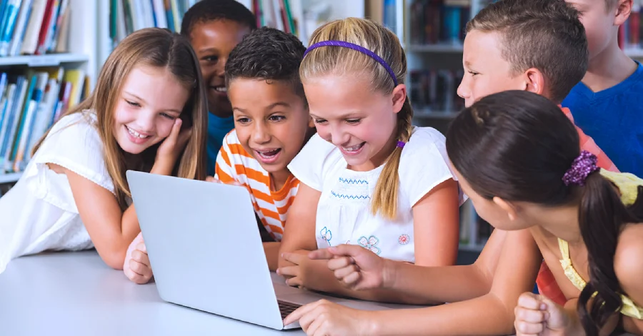  A multiethnic group of students with a laptop learning about multilingual captions and dubbing. 