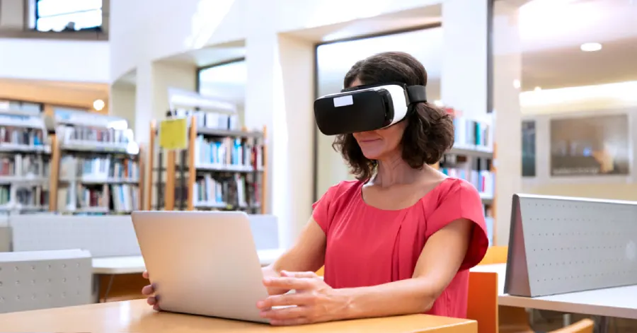 A female college student wearing a VR headset and learning about implementing challenges in immersive learning in higher education .