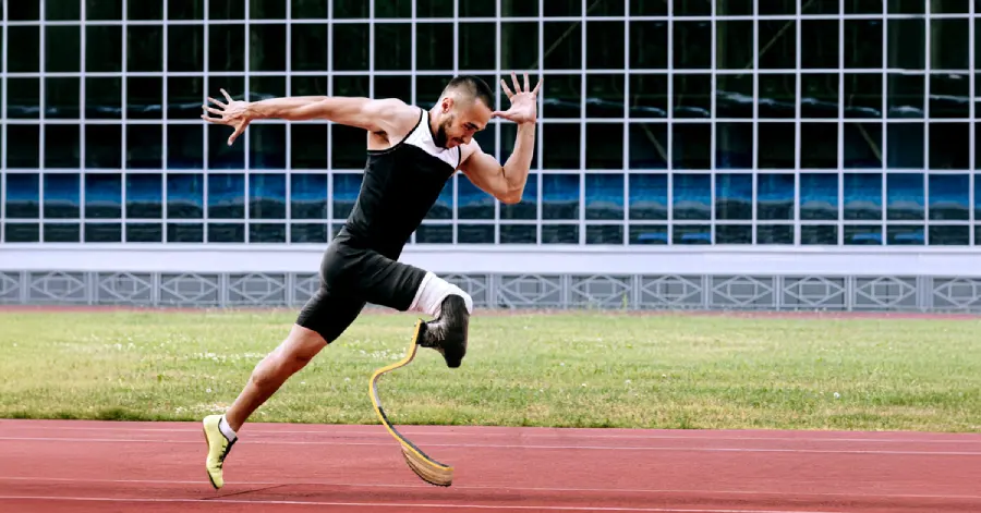 Image of a physically disabled athlete runner running on the track of a stadium. 