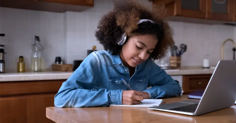 An image of a girl sitting with a laptop and learning. 