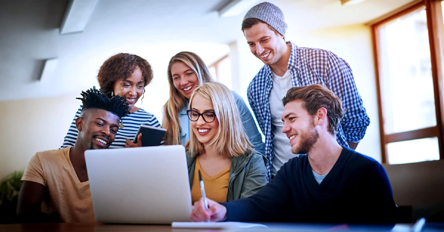  A multiracial group of students learning on a laptop. 
